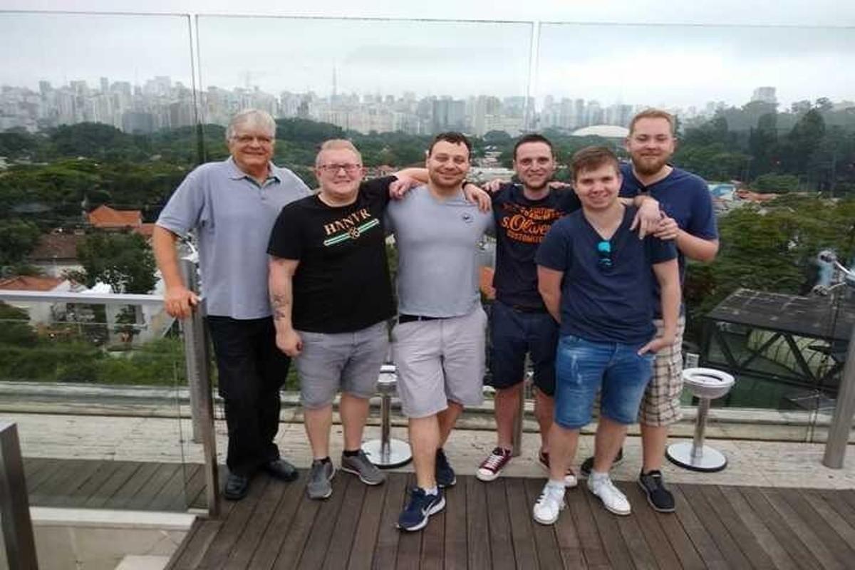 a group of men posing for a picture on a roof