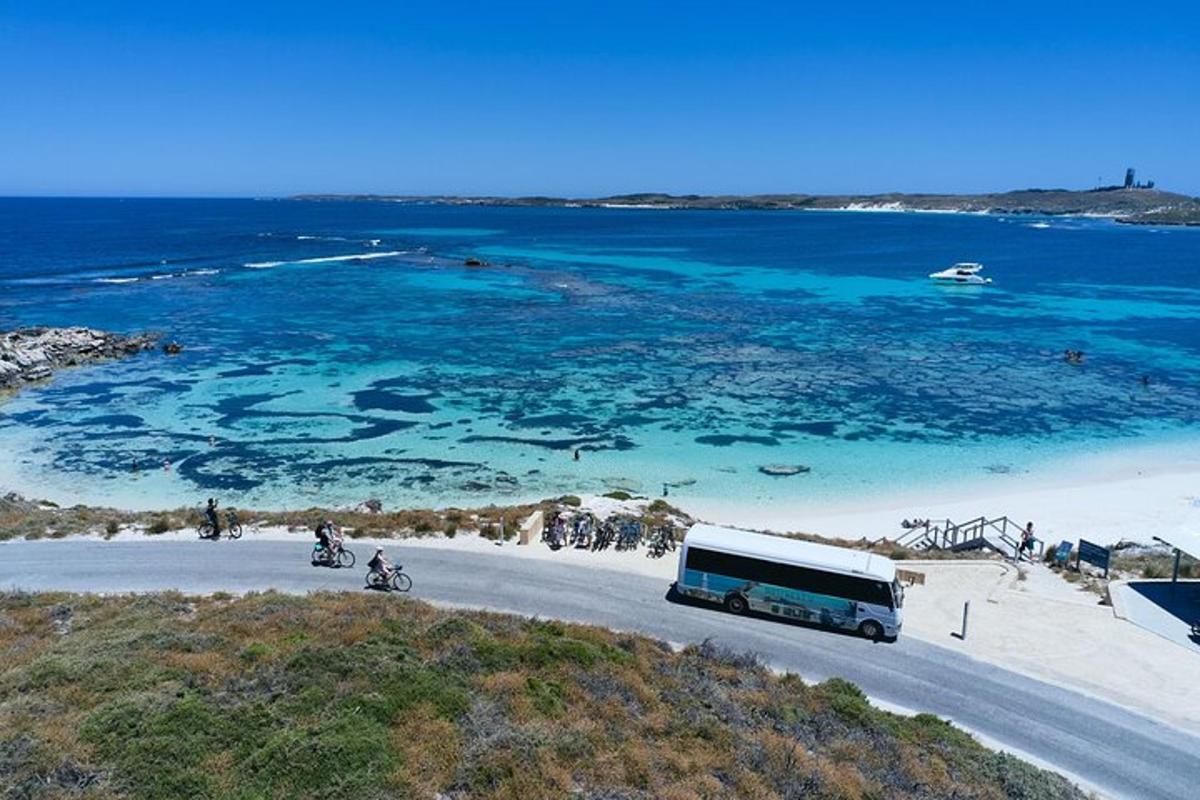 um ônibus dirigindo por uma estrada próxima ao oceano