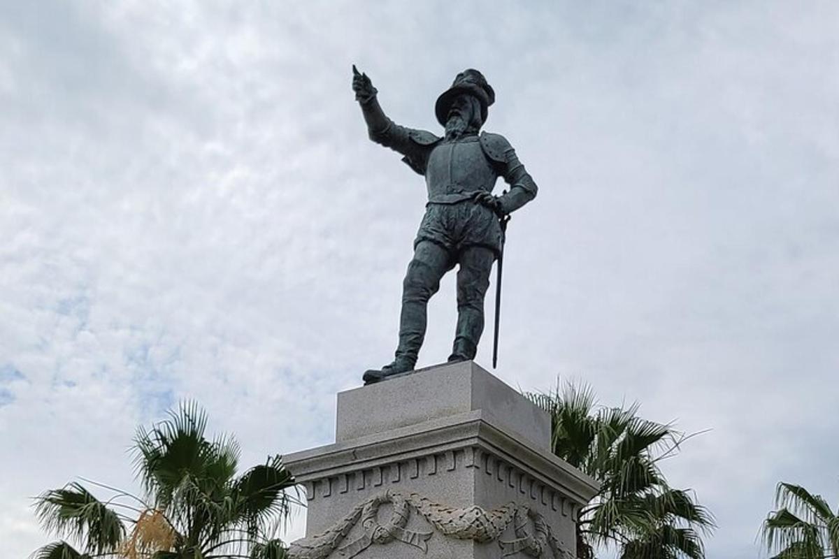 en statue av en mann som står på toppen av en bygning
