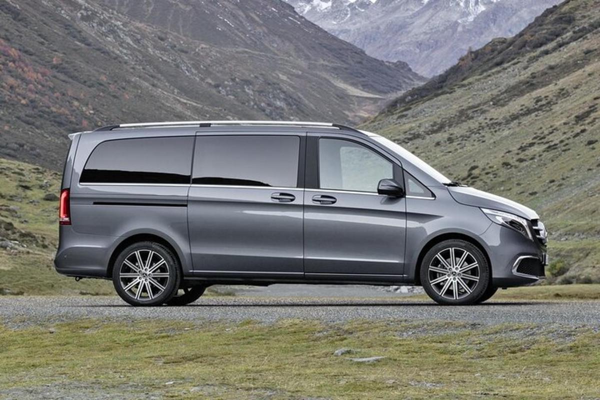 a silver van parked on a road near a mountain