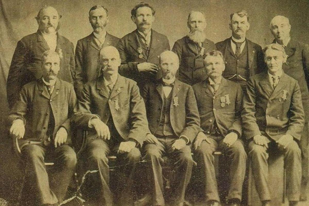 an old photo of a group of men posing for a picture