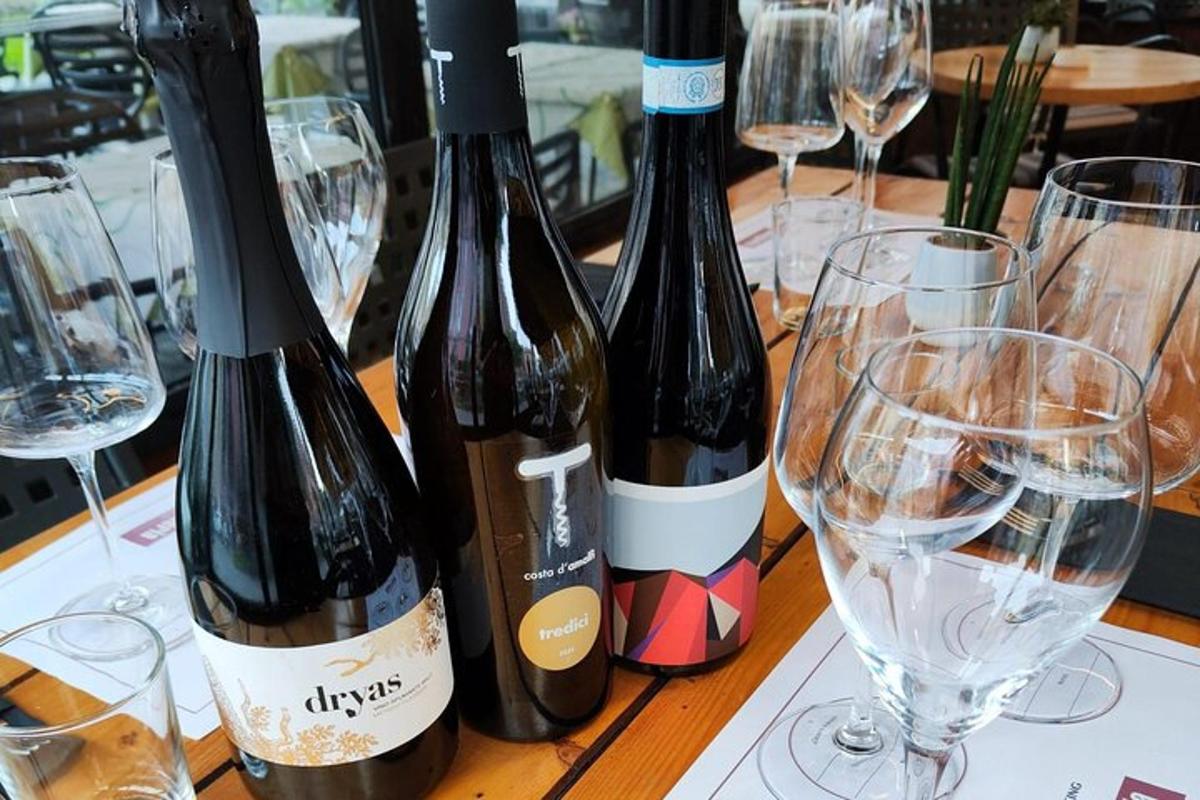 Tres botellas de vino sobre una mesa con copas.