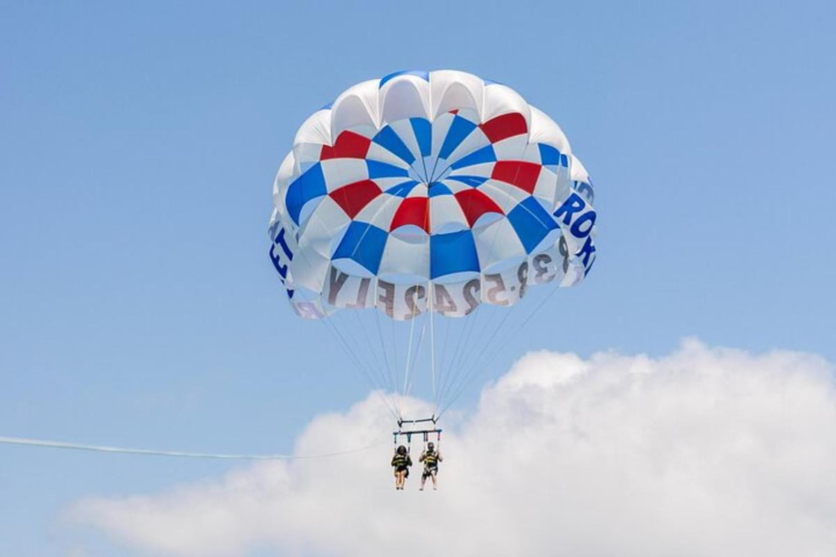 two people are riding on a parachute in the sky