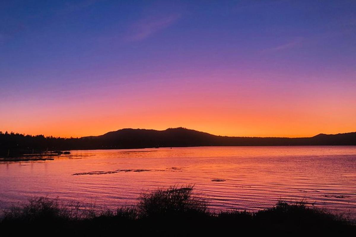 una posta de sol sobre una gran massa d'aigua