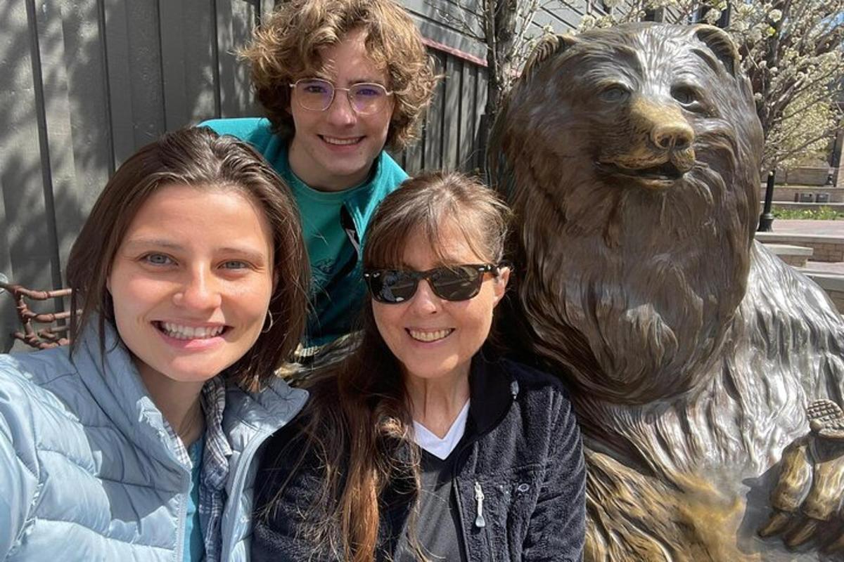 two women and a bronze statue of a bear