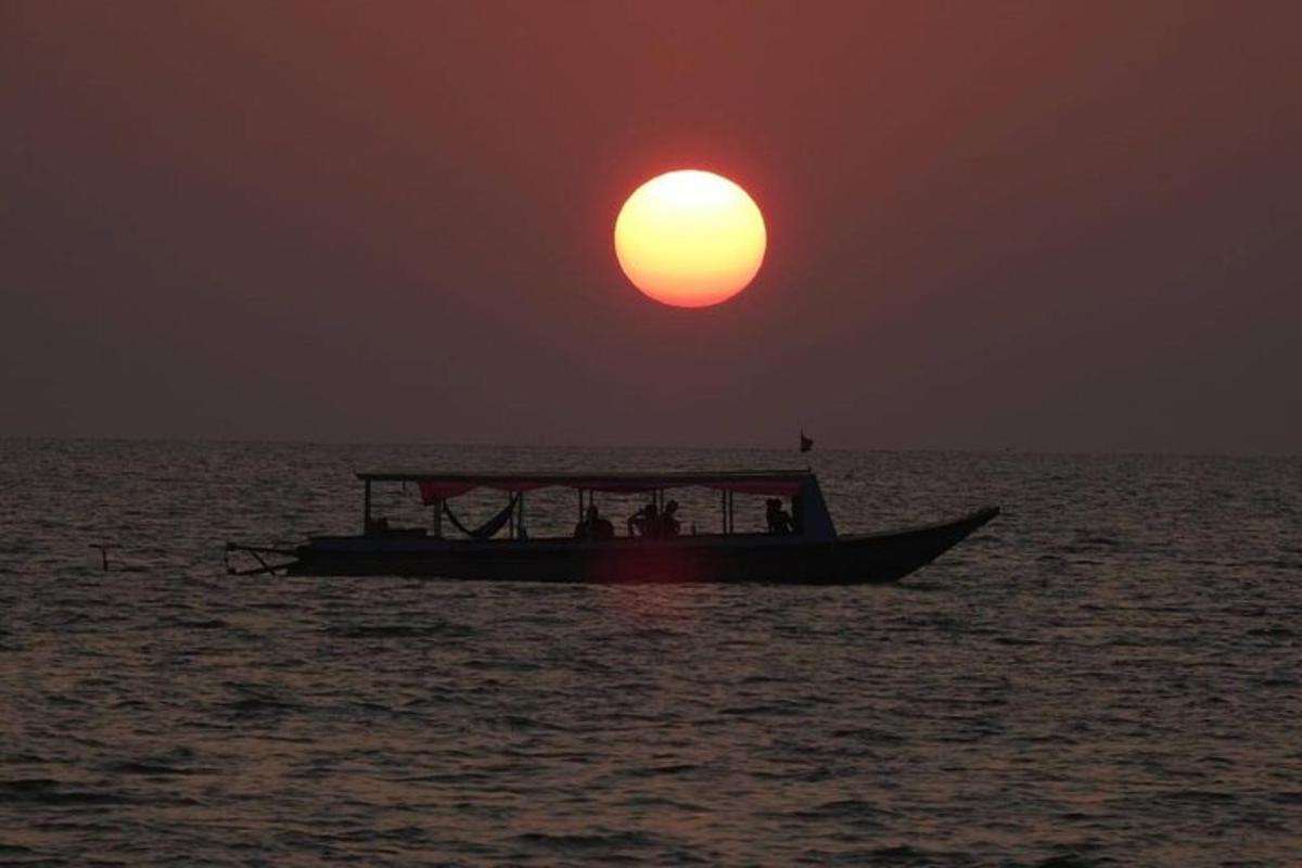 una barca nell'oceano con il sole nel cielo
