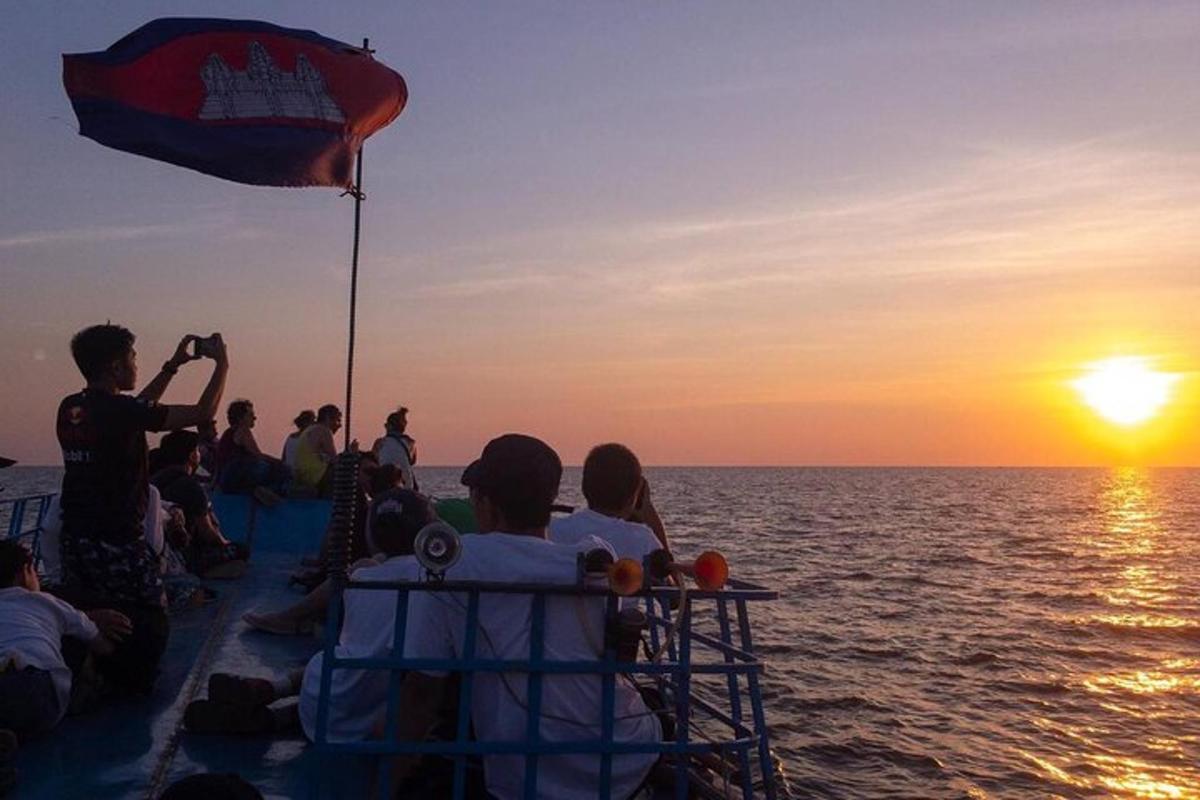 un gruppo di persone che guarda il tramonto su una barca