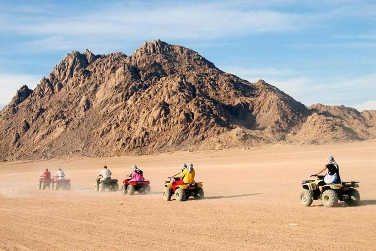 sekumpulan orang menunggang atv di padang pasir