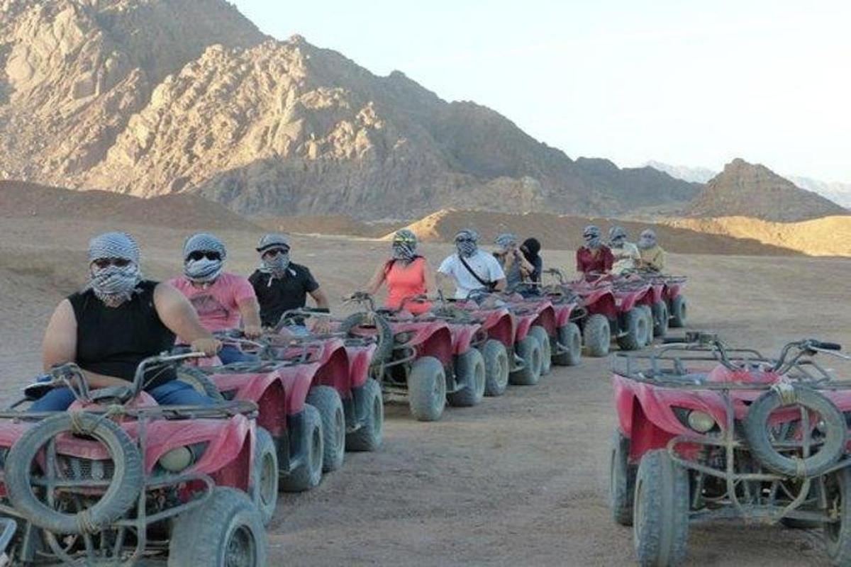 a group of people riding atvs in the desert