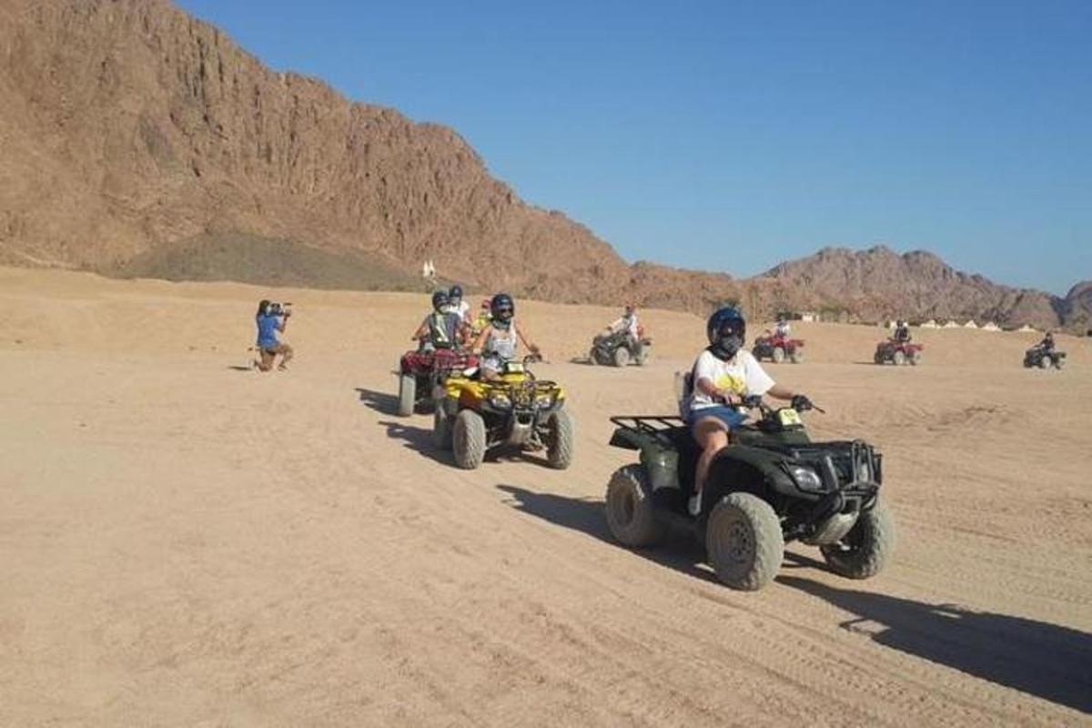 sekumpulan orang menunggang atv di padang pasir