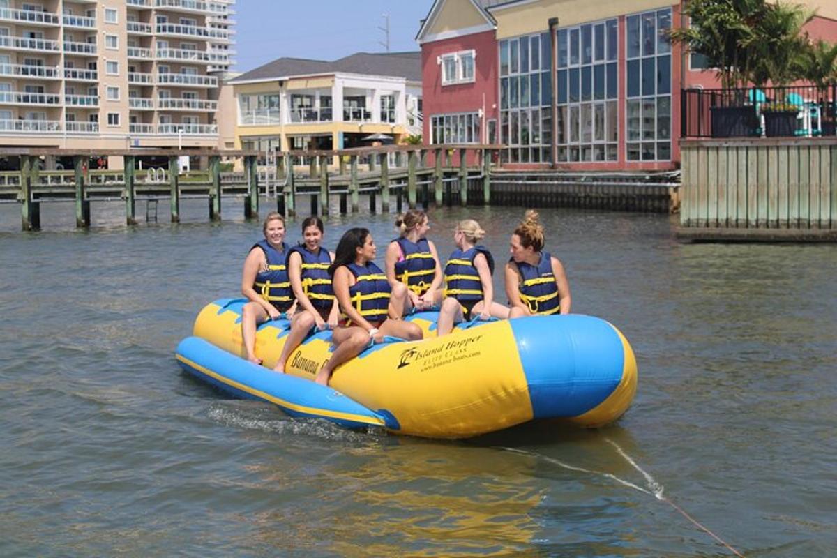 a group of girls in life jackets riding on a raft on the water