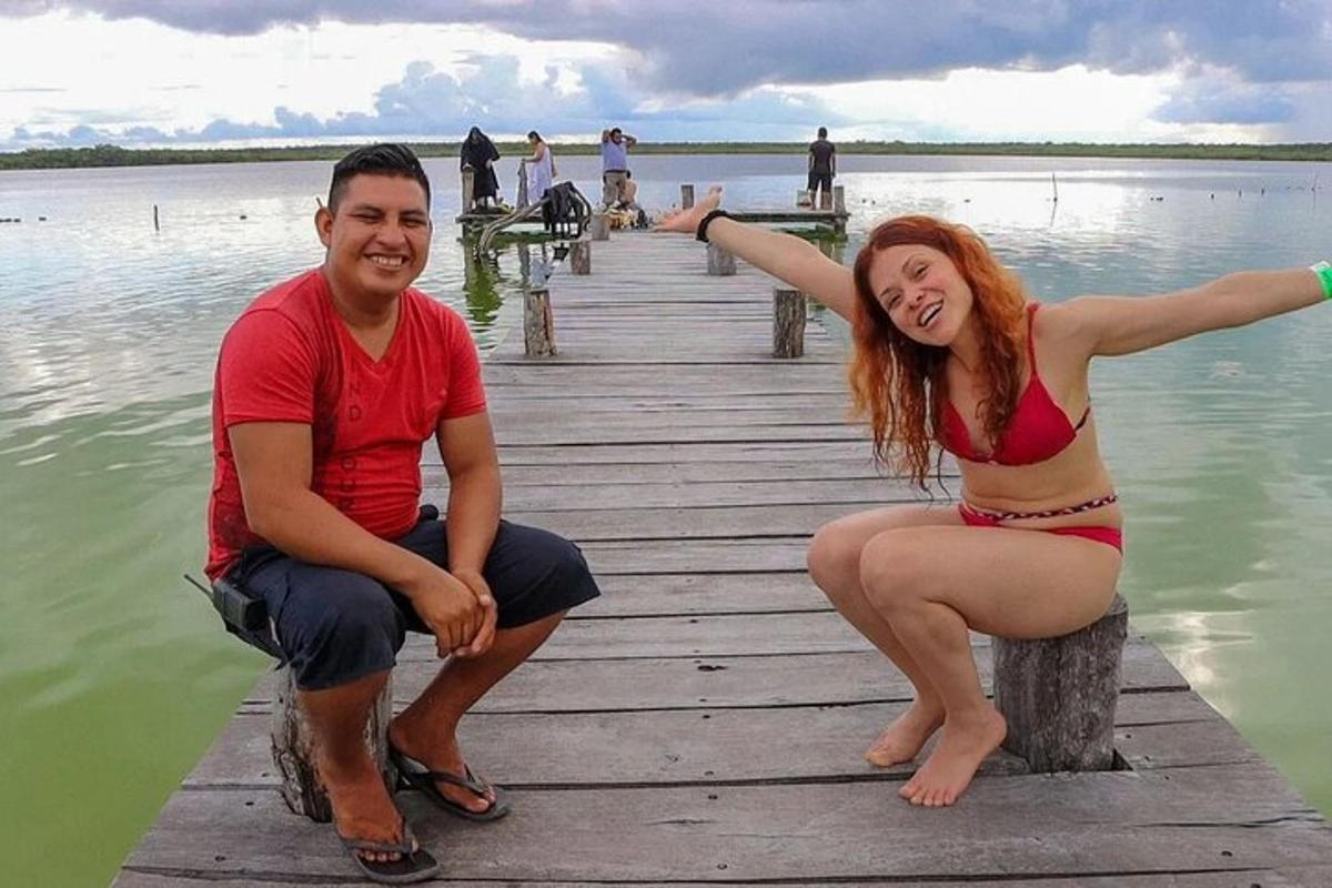 un uomo e una donna seduti su un molo in acqua