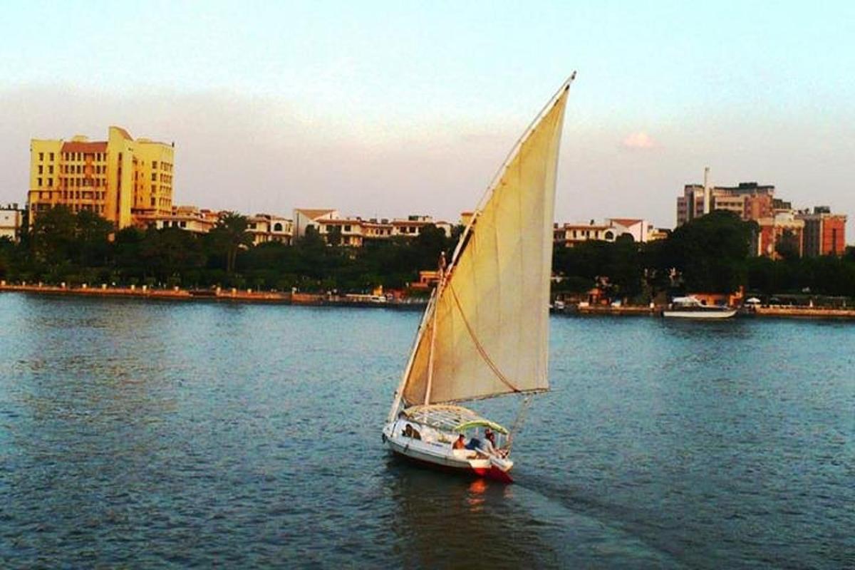 una barca a vela in acqua con una città sullo sfondo