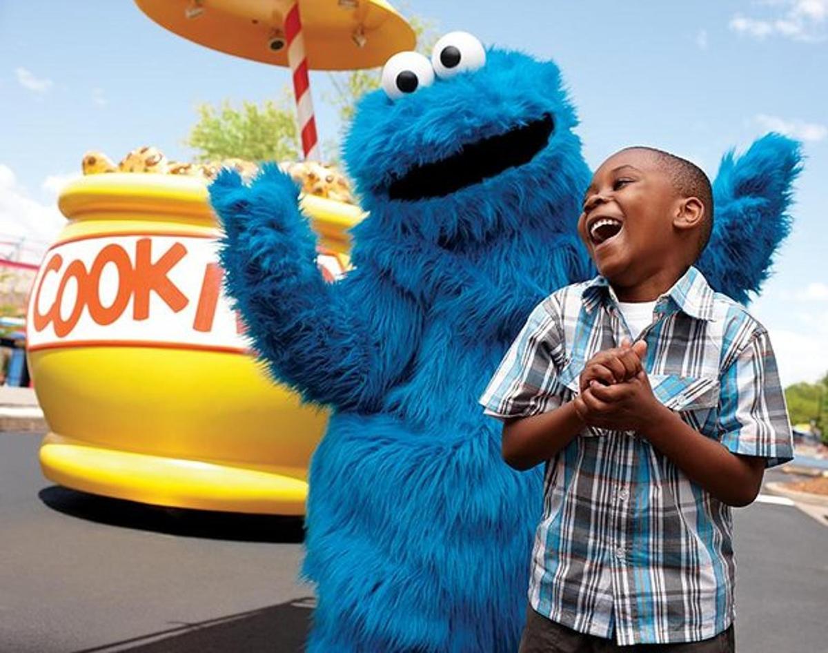 a young boy standing next to a blue mascot