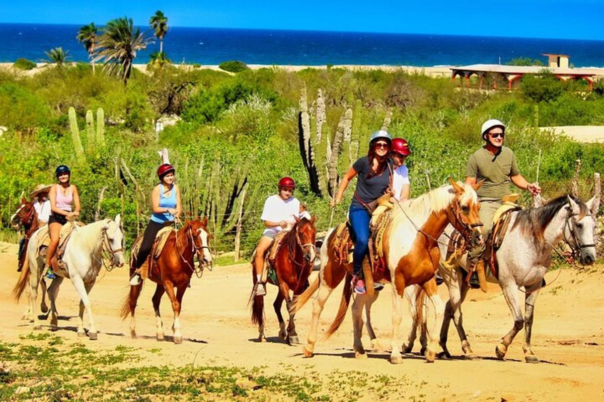 un gruppo di persone a cavallo sulla spiaggia