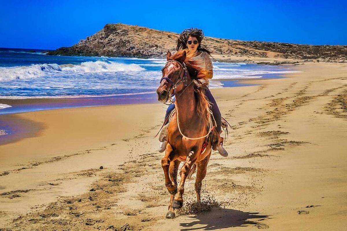 una donna a cavallo sulla spiaggia