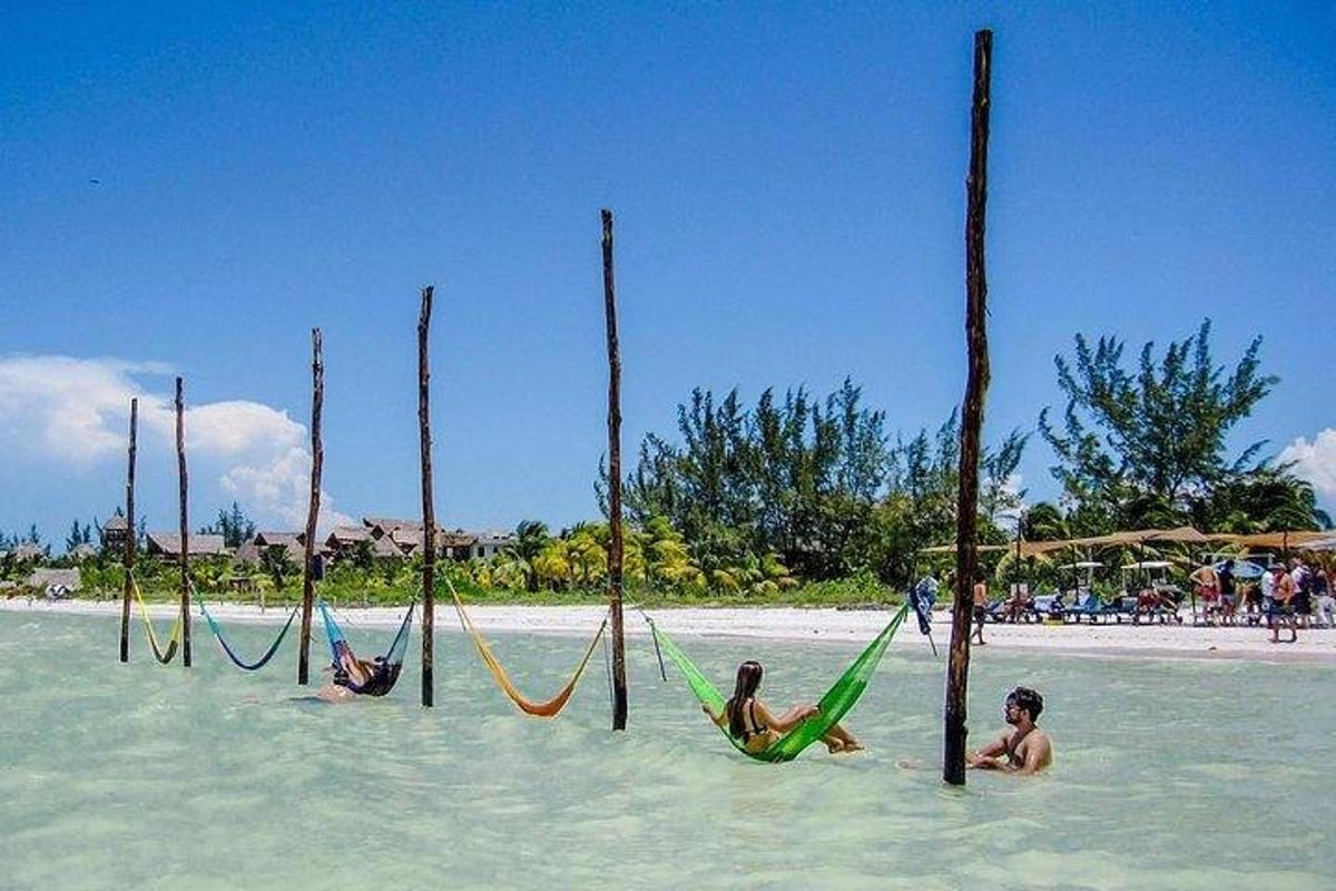 a group of people laying in hammocks in the water