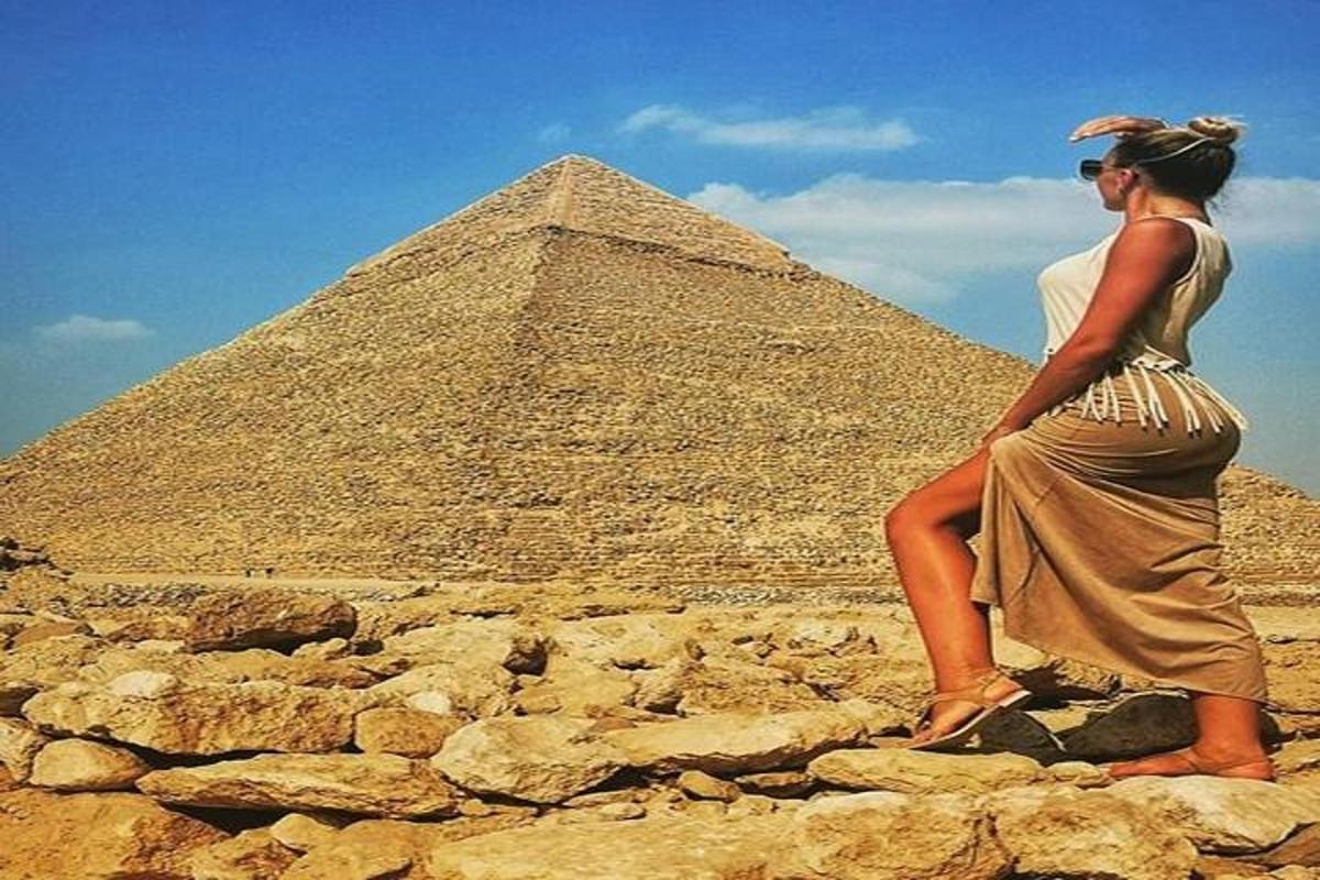 μια γυναίκα που στέκεται μπροστά σε μια πυραμίδα
