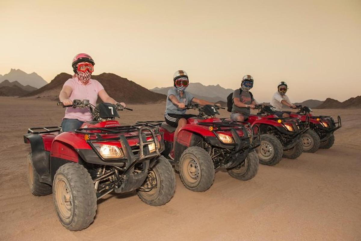 un gruppo di persone in sella a quad nel deserto