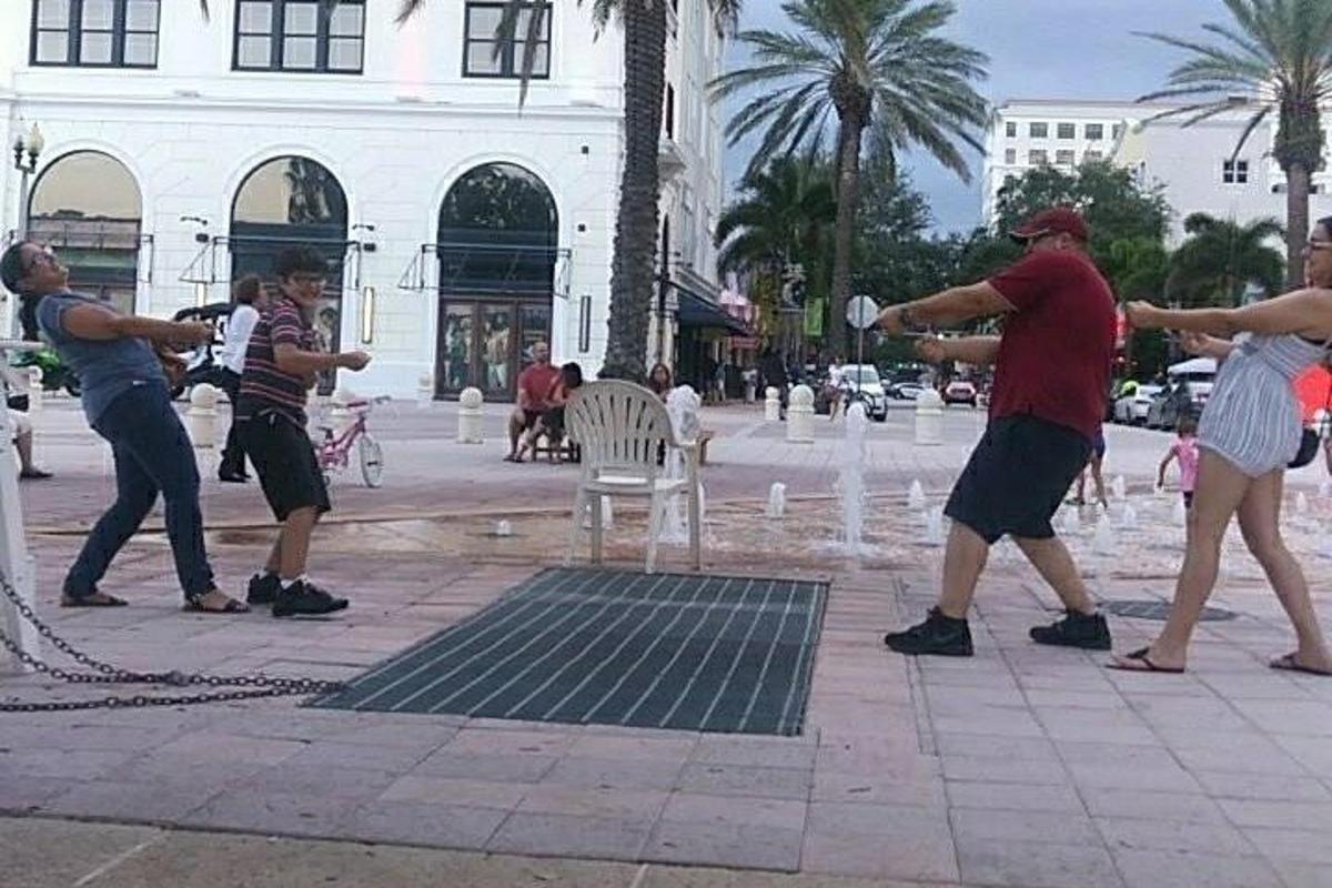 eine Gruppe von Menschen, die Frisbee in einem Brunnen spielen