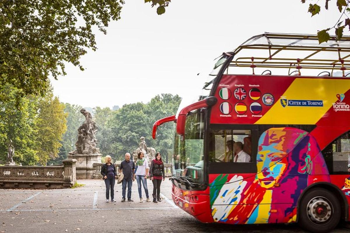 Egy piros emeletes busz parkolt egy szobor előtt