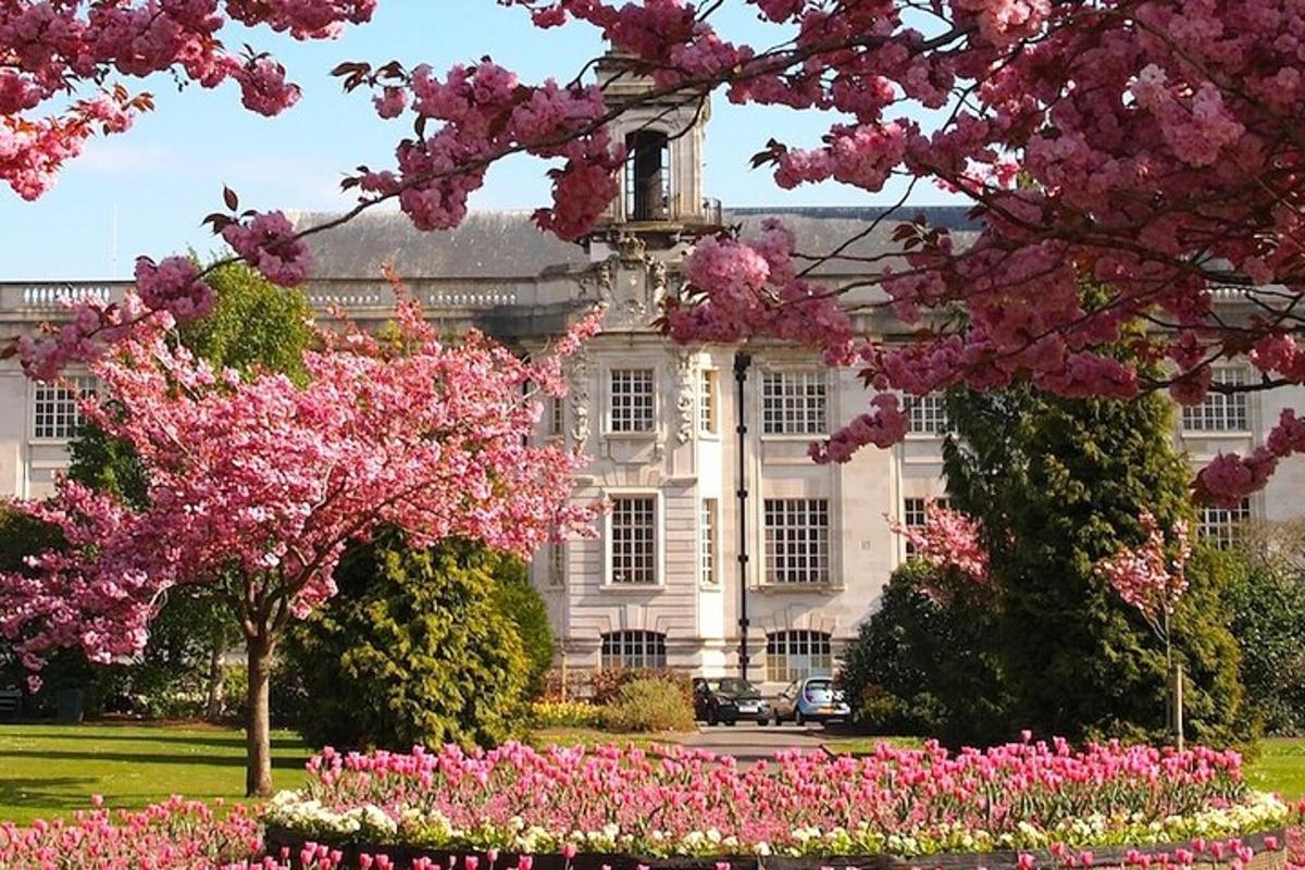 a large building with pink flowers in front of it