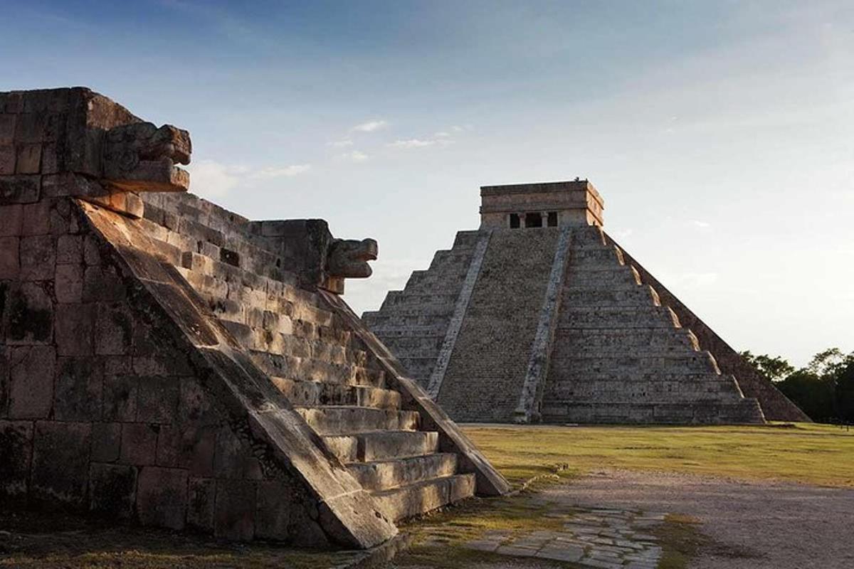 uma pirâmide com um muro de pedra ao lado de um campo
