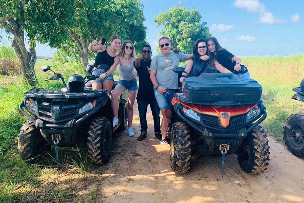 Un grupo de personas posando para una foto junto a vehículos todo terreno.