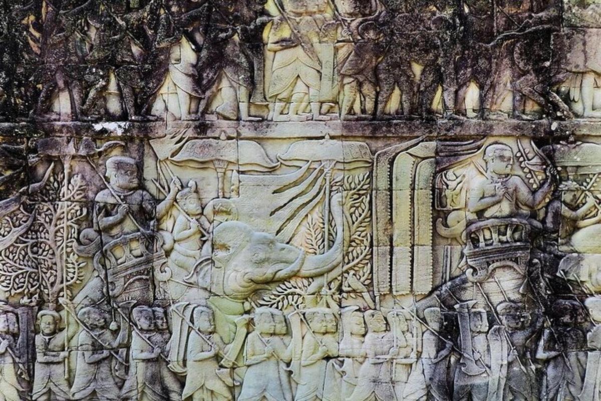 un muro di pietra con un rilievo di persone ed elefanti