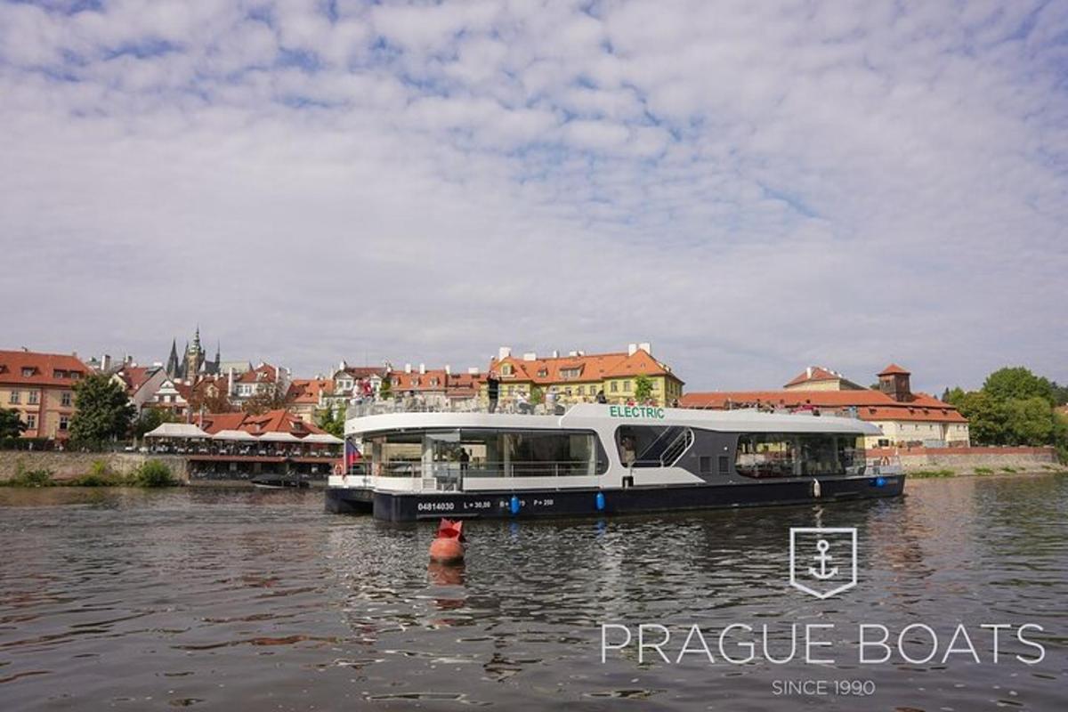 loď na řece s městem v pozadí