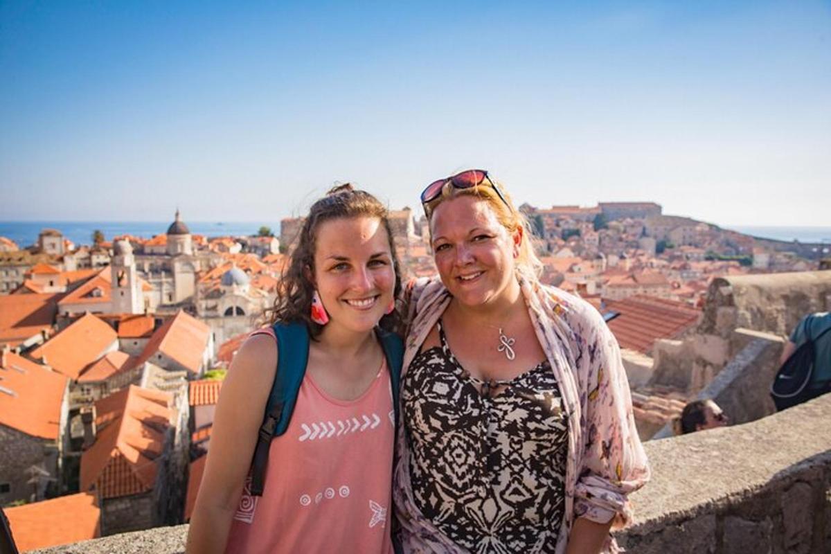 duas mulheres posando para uma foto no topo de uma cidade