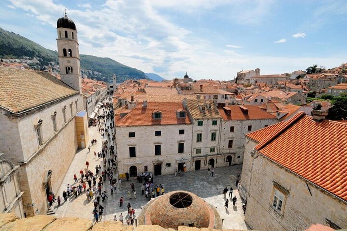 um grupo de pessoas caminhando por uma cidade com uma torre do relógio