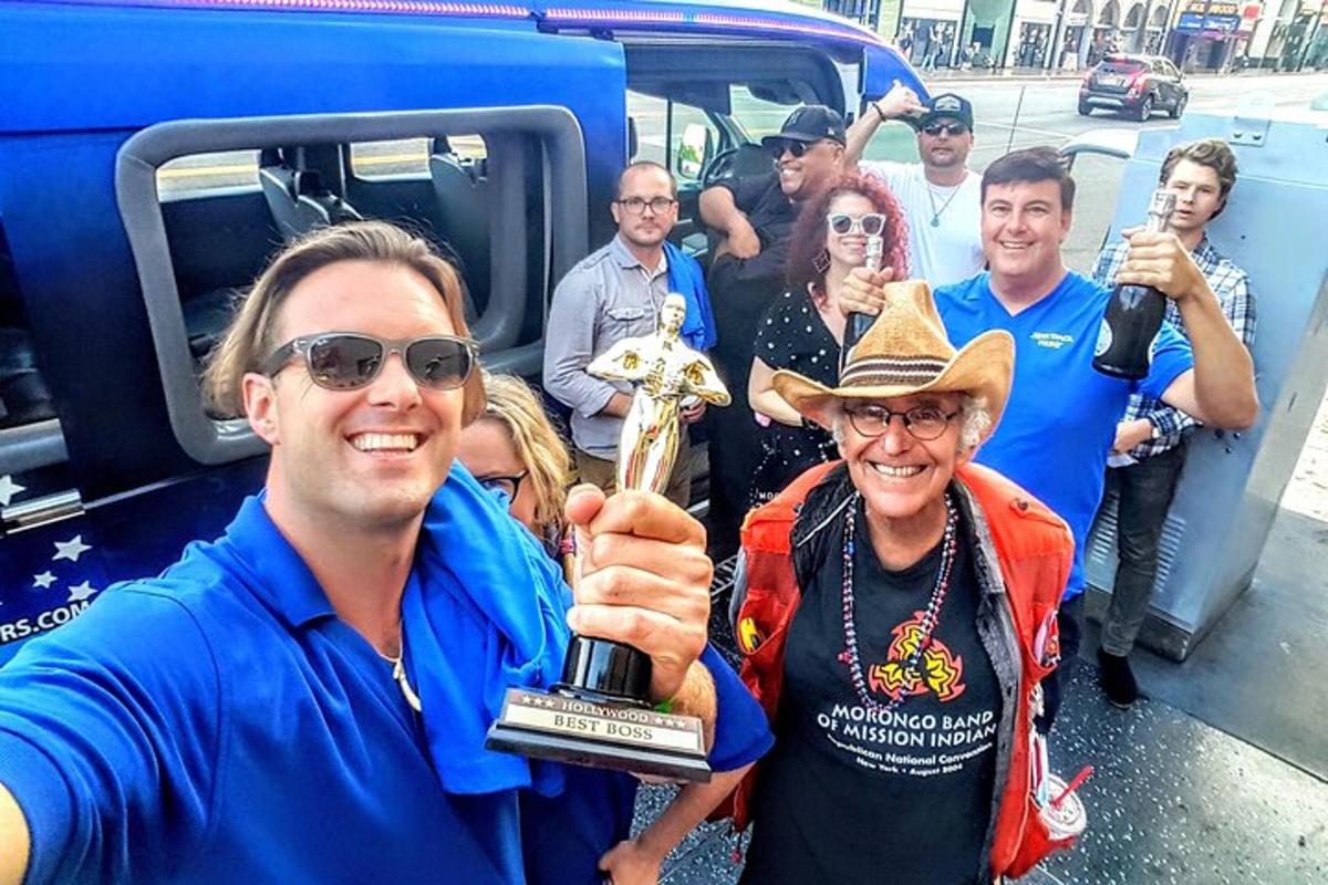 a group of people posing with a man holding a trophy