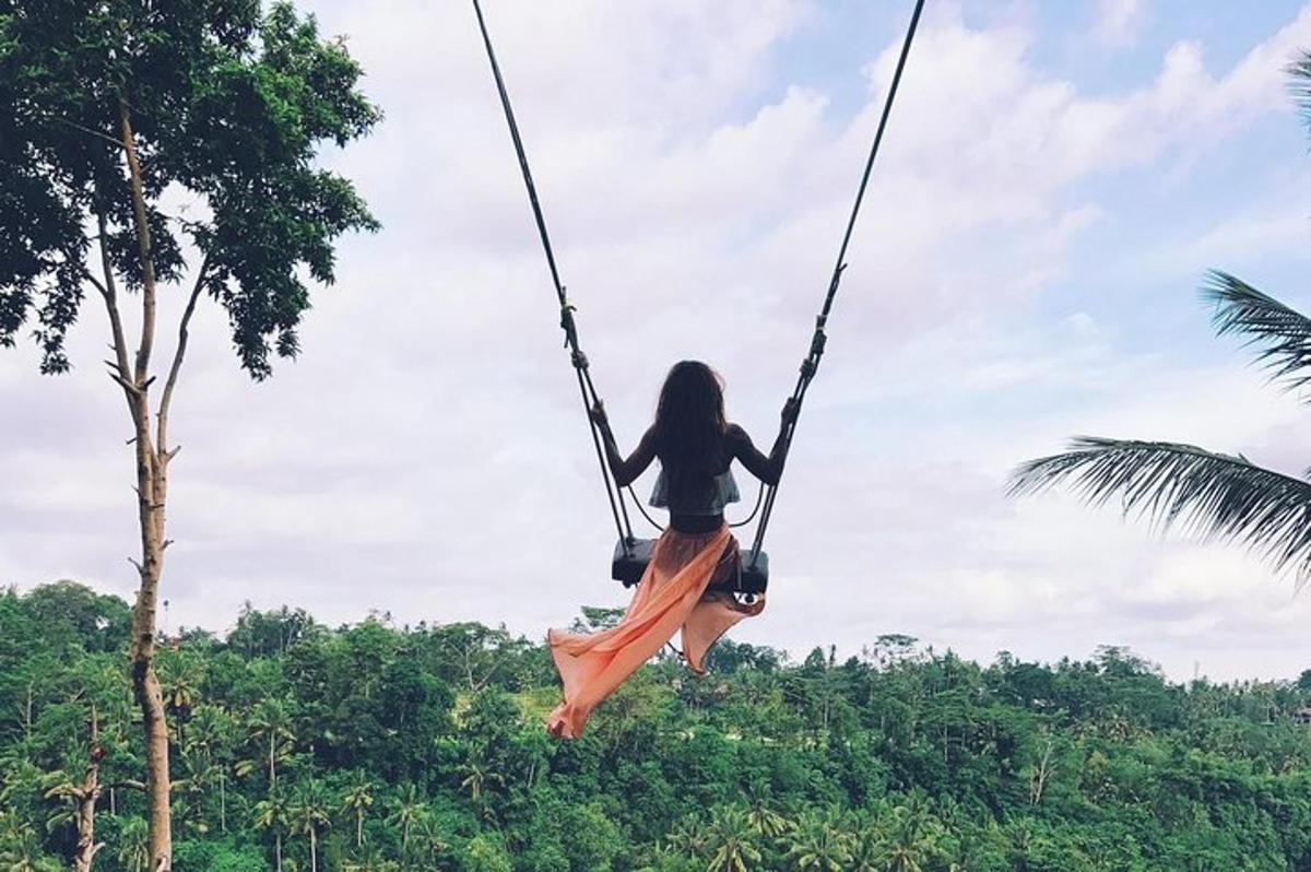 a woman on a swing in the jungle