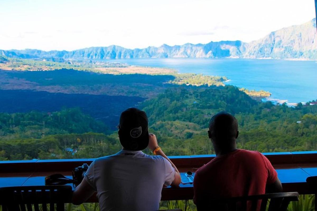 two people sitting on a bench looking out at the water