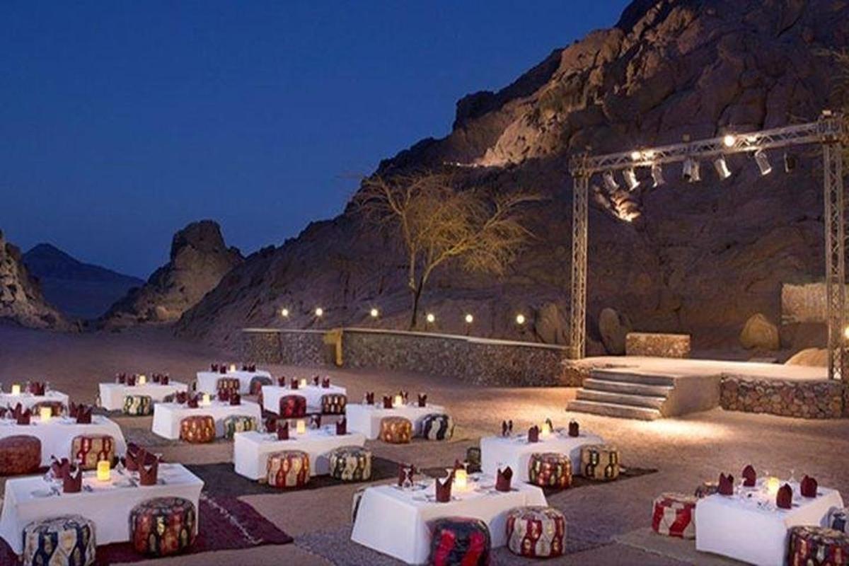 a group of tables and chairs in front of a mountain