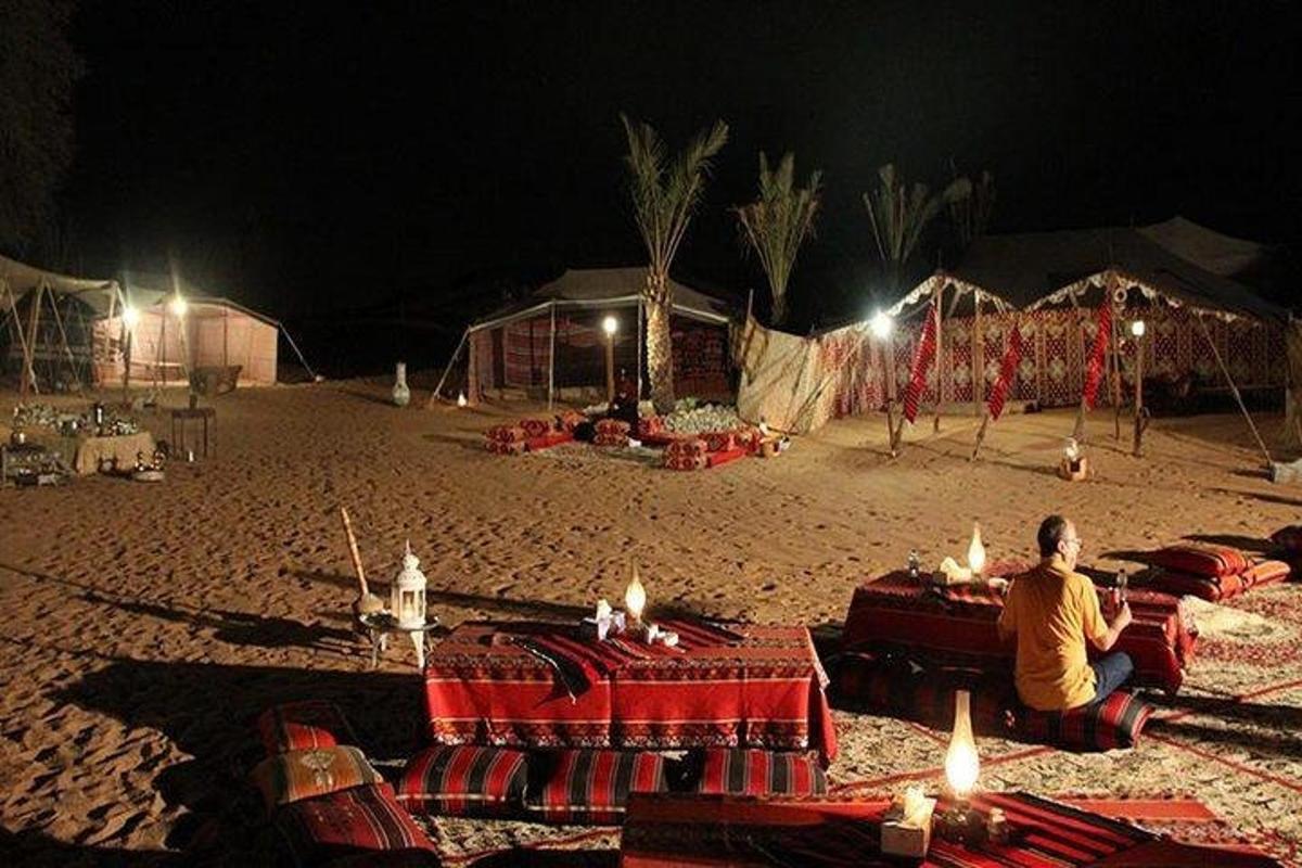 a man sitting on a beach at night