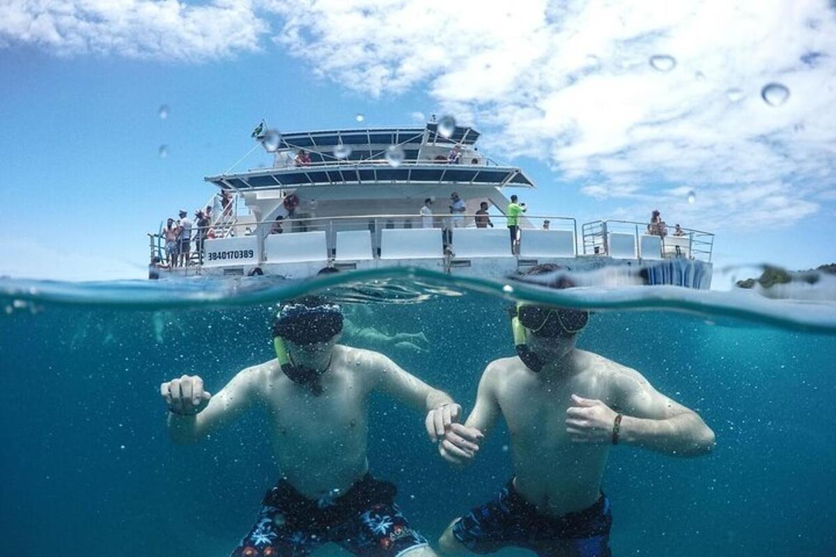 two men in the water in front of a boat