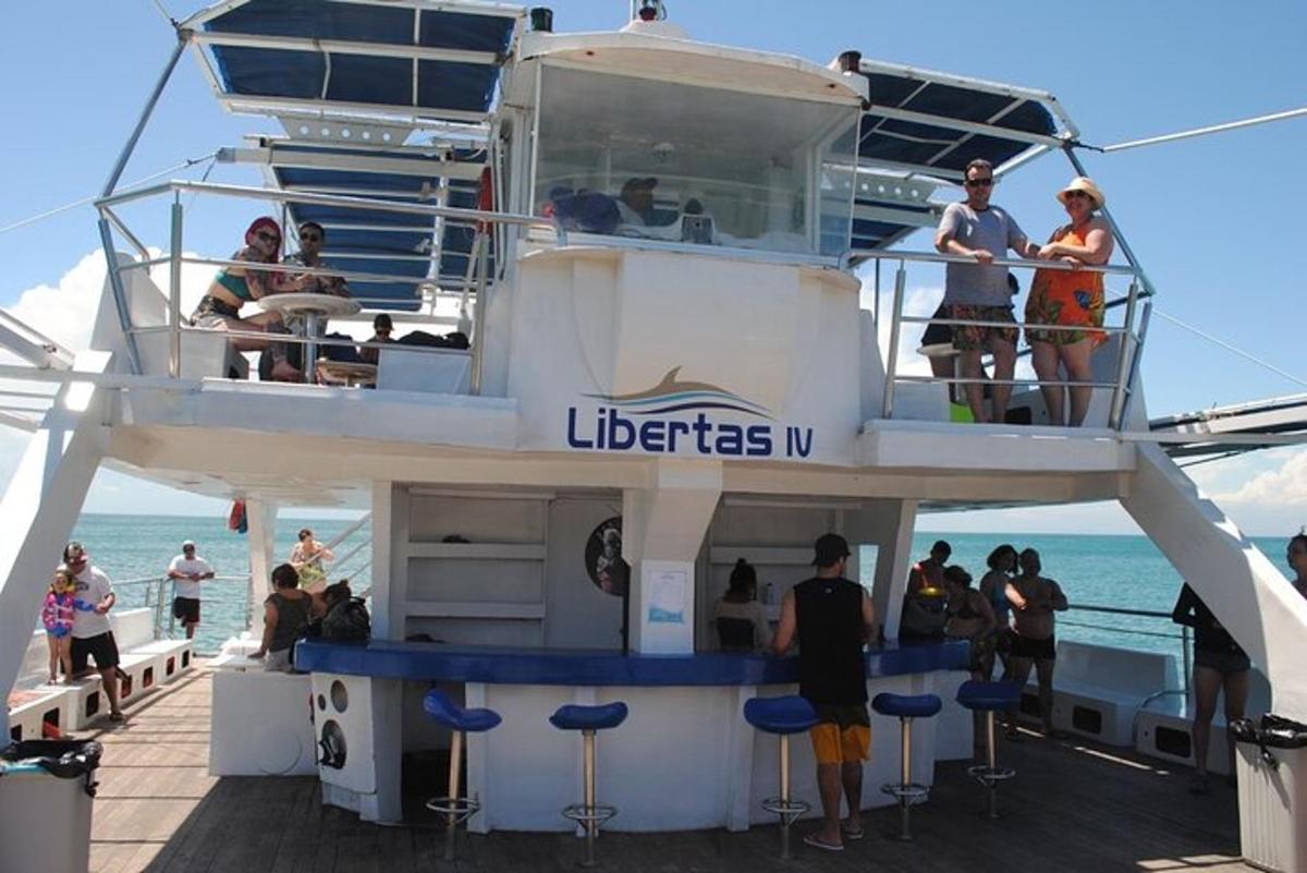 a group of people standing on the deck of a boat