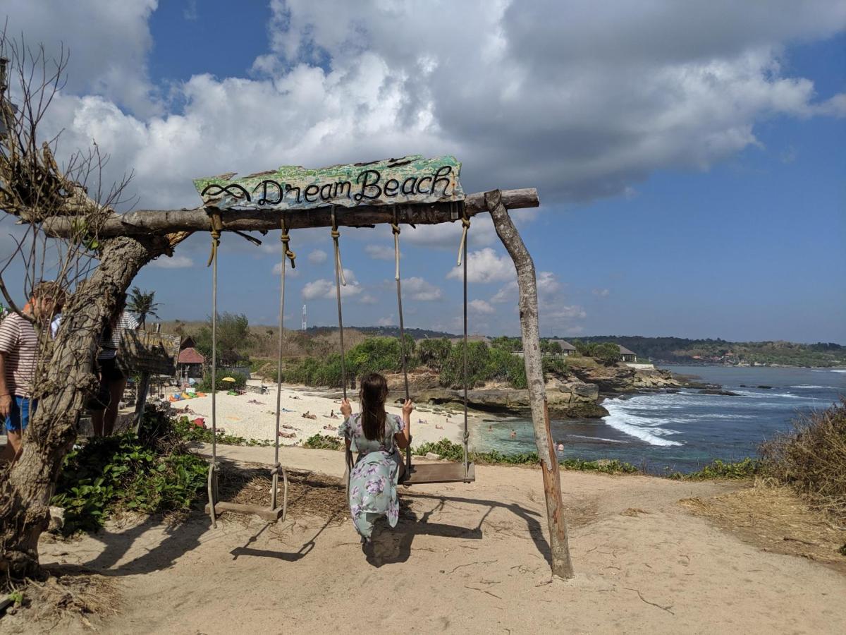 a girl sitting on a swing at a beach