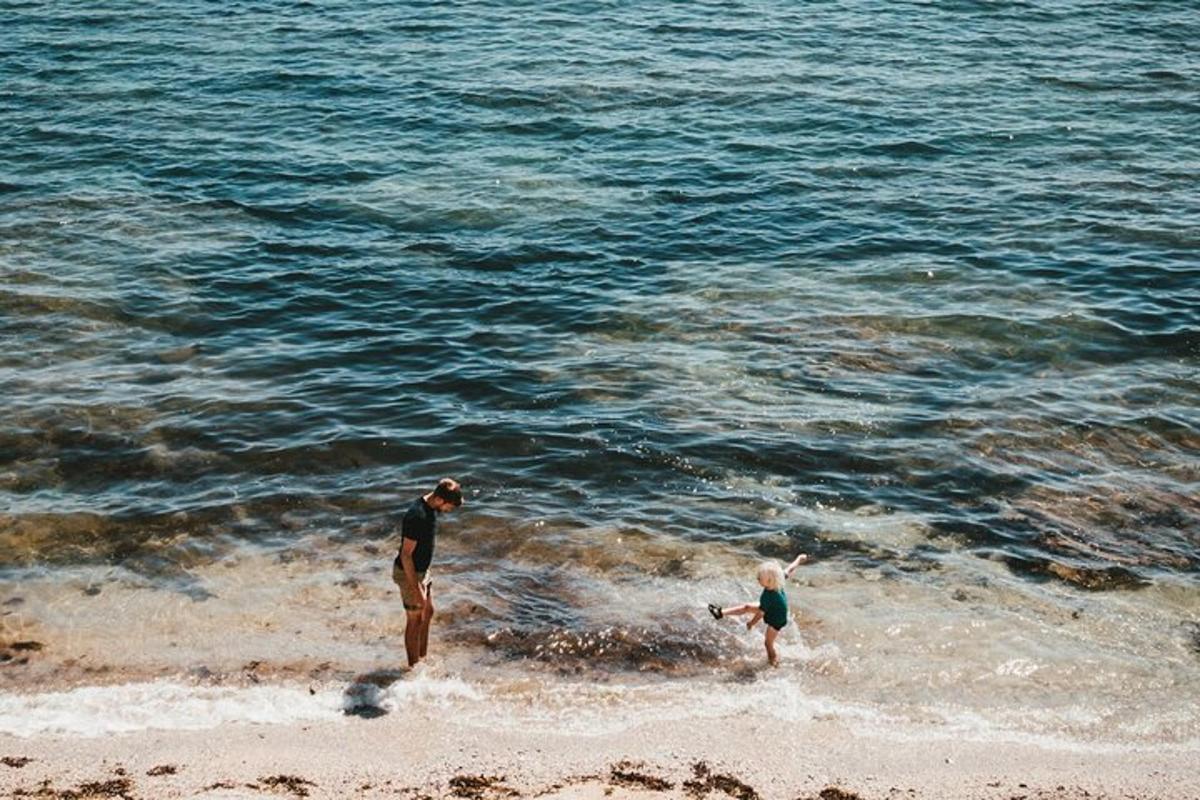 a man and a child playing in the water at the beach