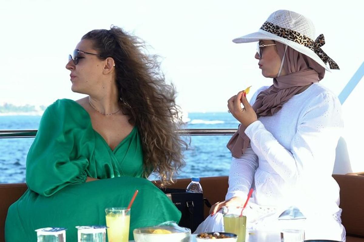 Dos mujeres sentadas en un barco mirando un teléfono celular
