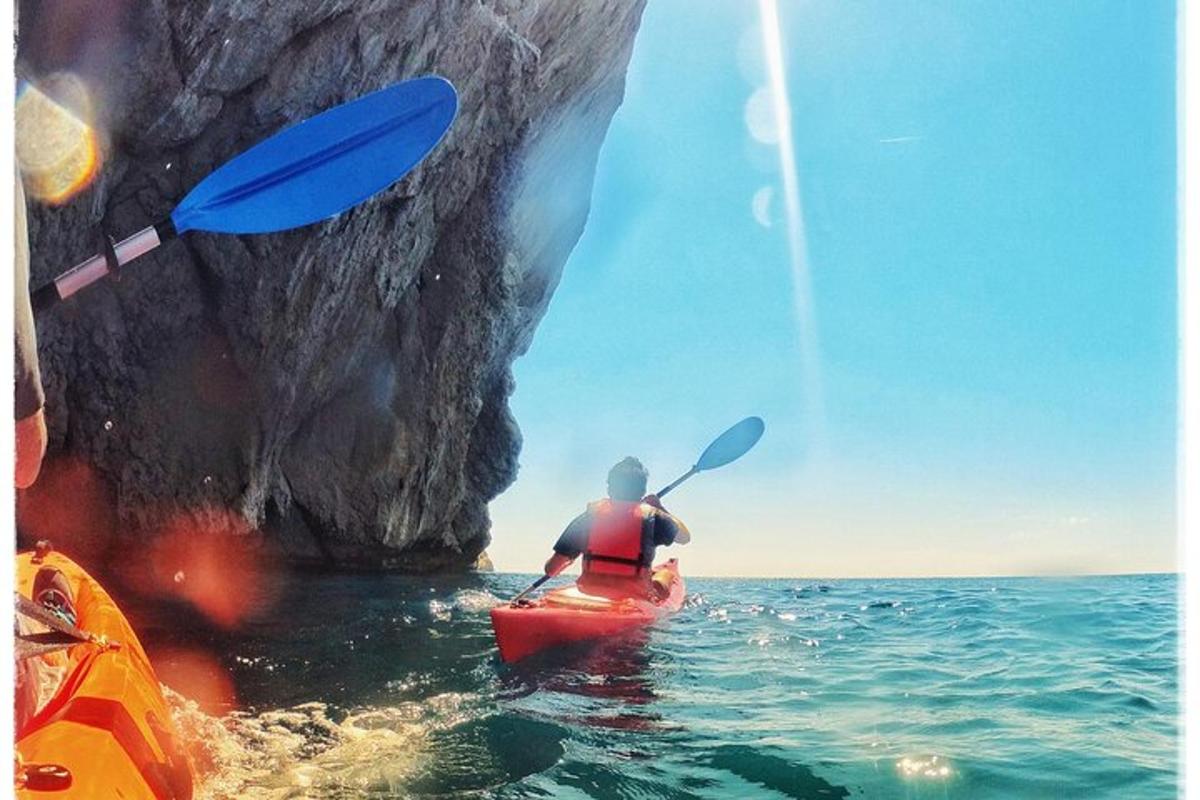 una persona in kayak in acqua vicino a una roccia