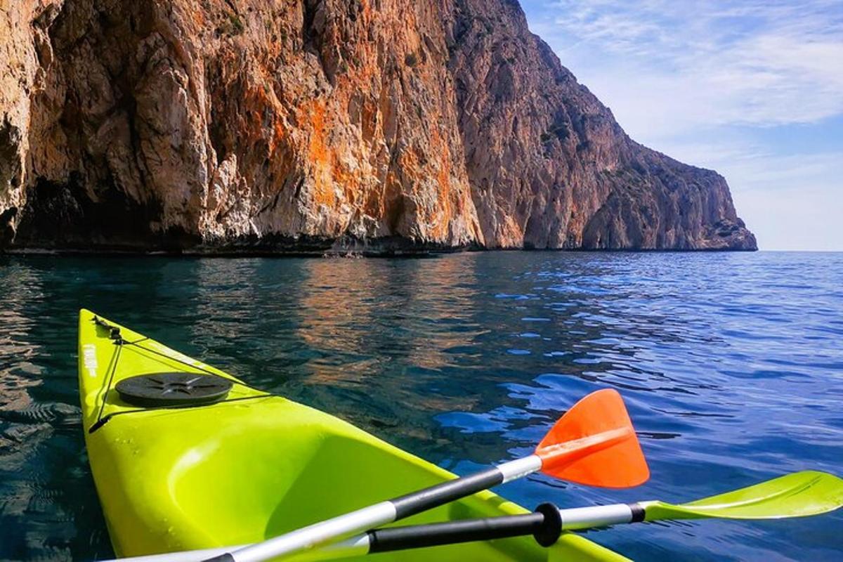 un kayak giallo nell'acqua accanto a una montagna
