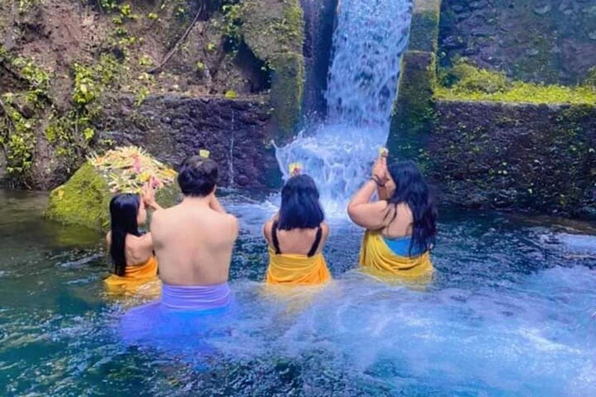 một nhóm người đang ngồi trước thác nước