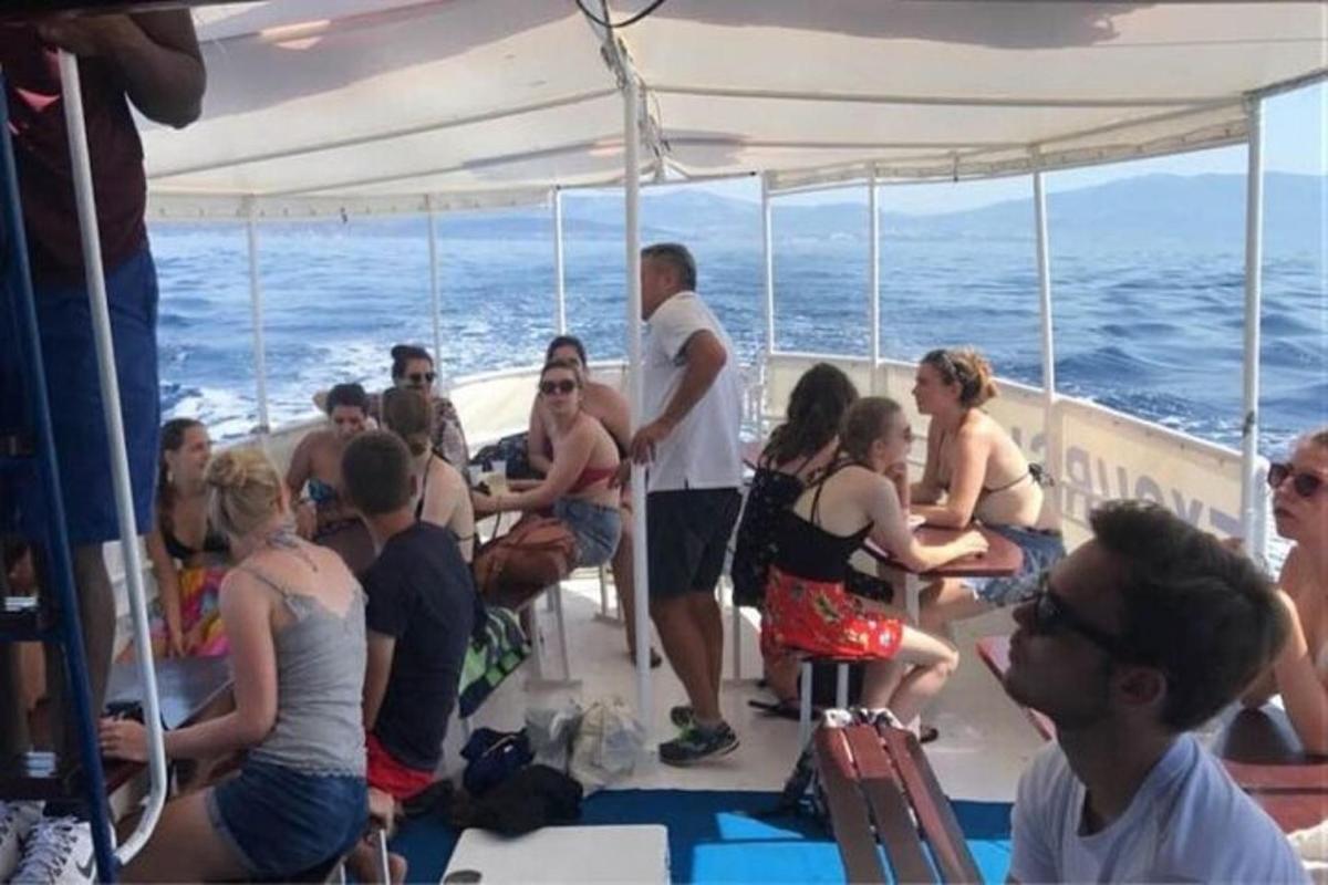 a group of people sitting on the deck of a boat