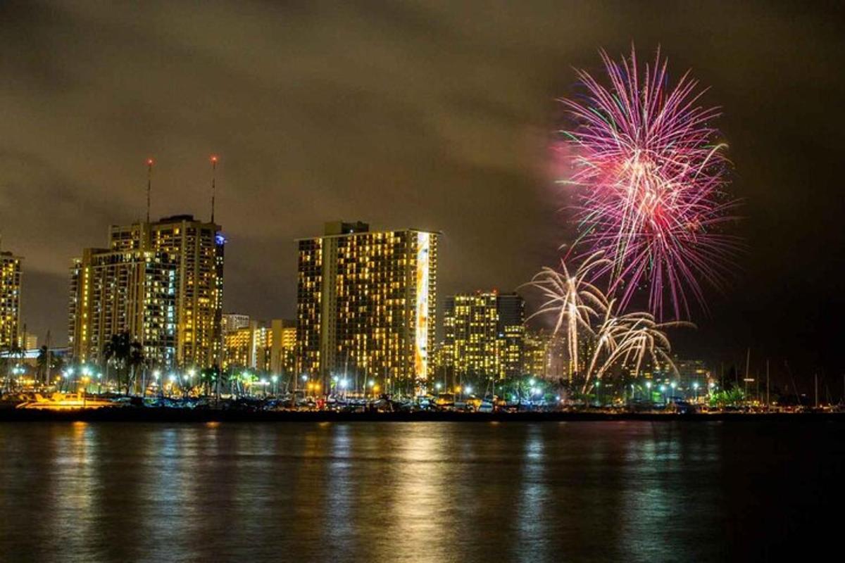 Un espectáculo de fuegos artificiales frente a una ciudad por la noche.