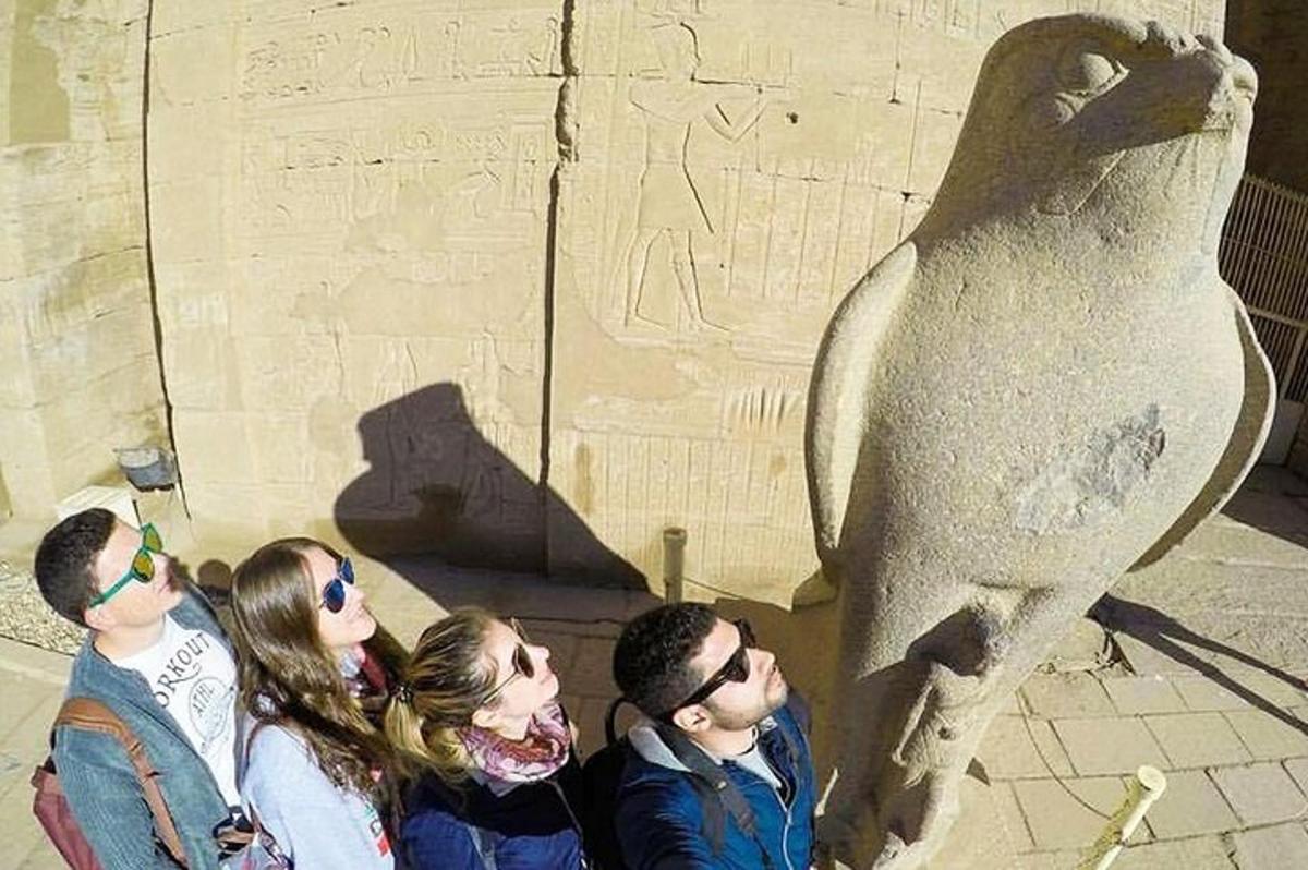 um grupo de pessoas em pé em frente a uma estátua