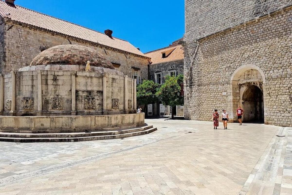 two people standing in front of a building with a fountain