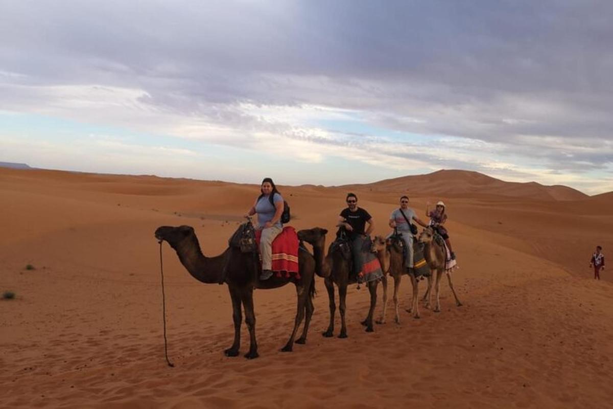 a group of people riding on camels in the desert
